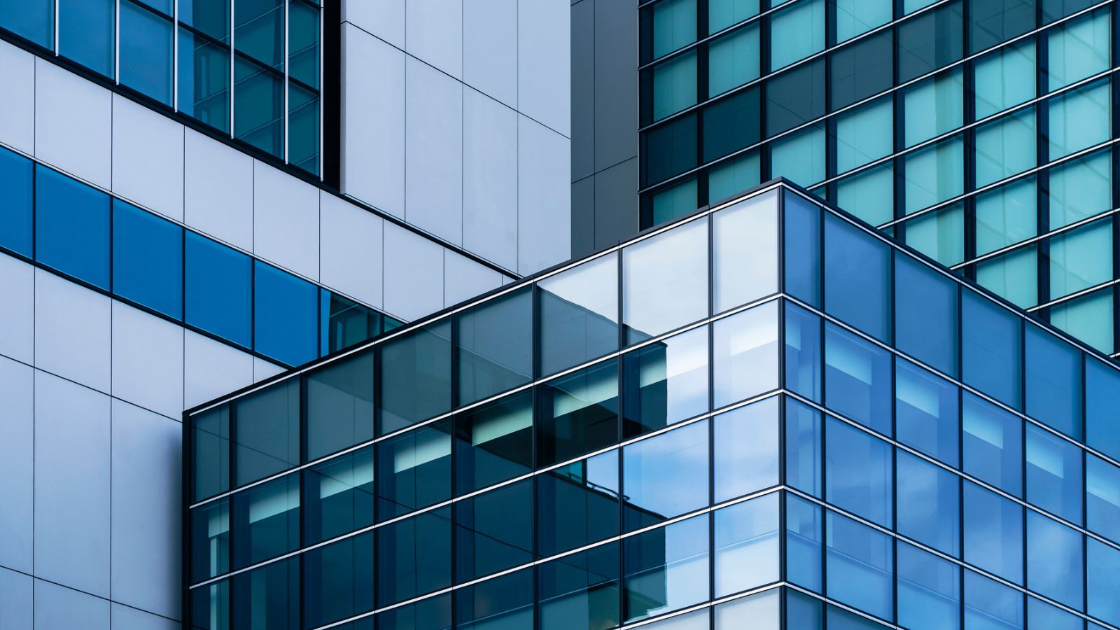 Abstract glass building exteriors reflect the structured transparency and predictability provided by managed data pipelines